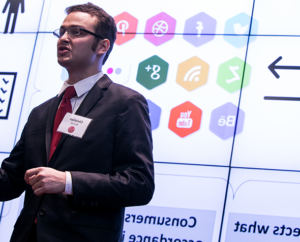 Male student in a suit presenting at the Race 和 Case business competition